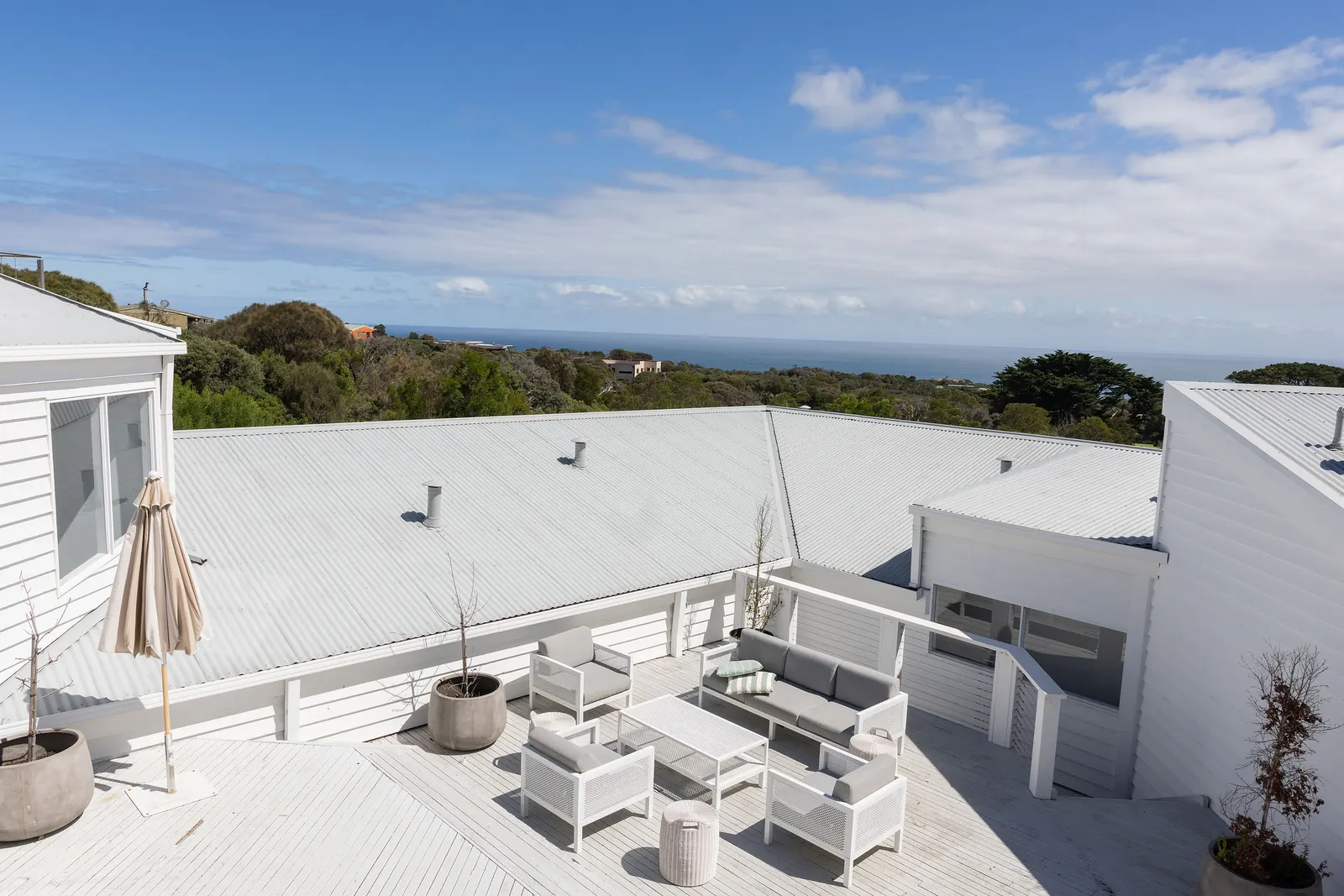 The Cape Retreat's white deck, looking over the bush to the ocean