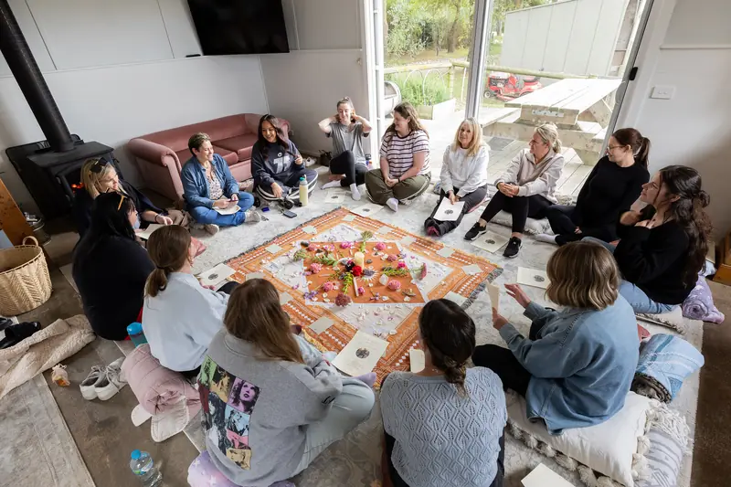 Guests in the opening circle around a rug of flowers