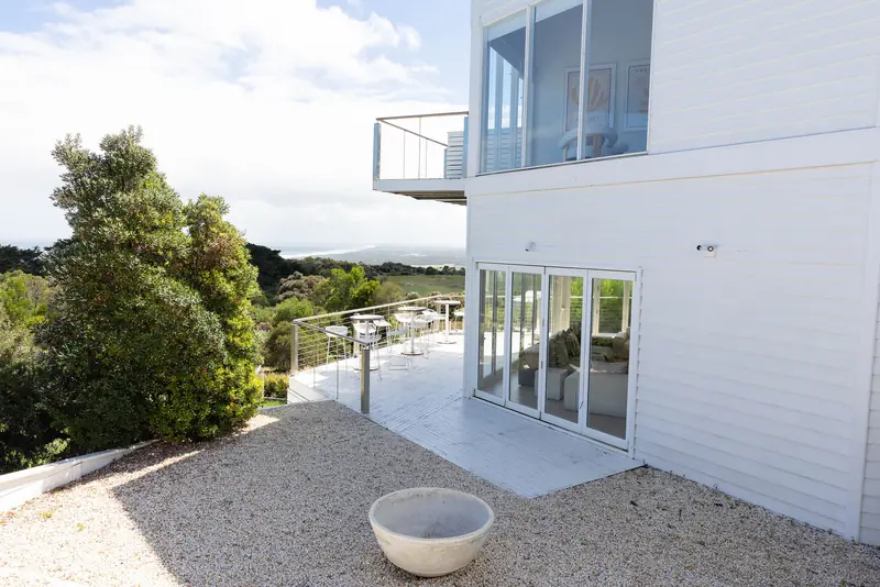 The house’s white terraces with the bush beyond