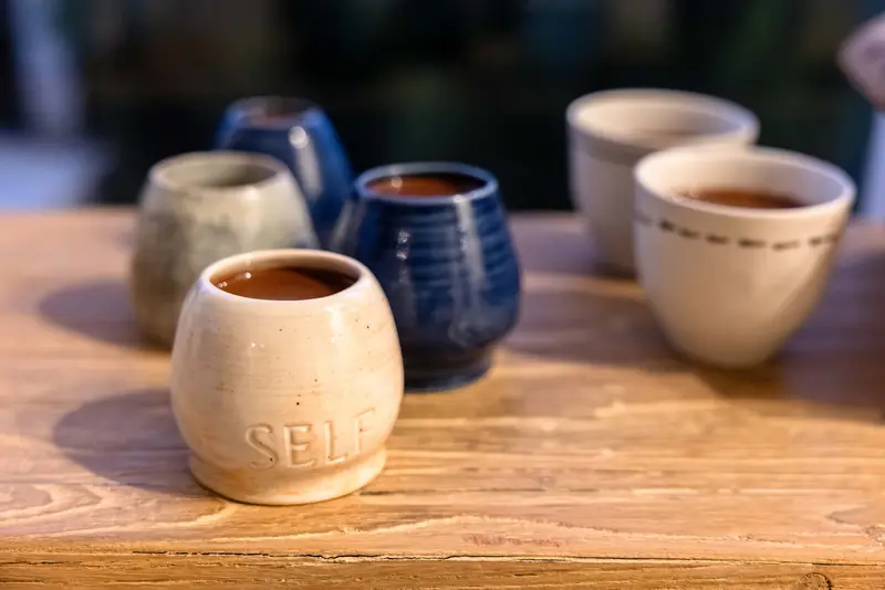 A cup stamped SELF, filled with cacao