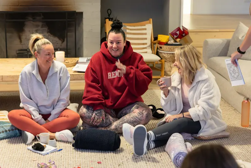 Guests on the floor with cups of cacao, laughing