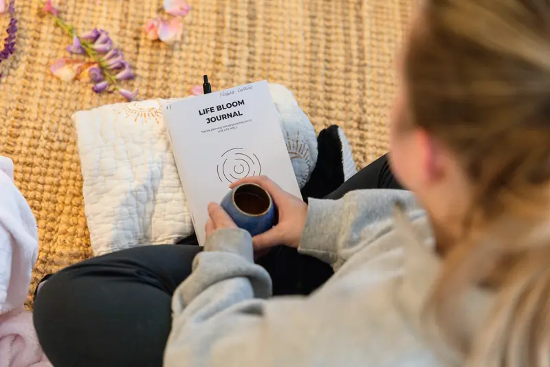 A cup of cacao and a journal in a guest’s lap