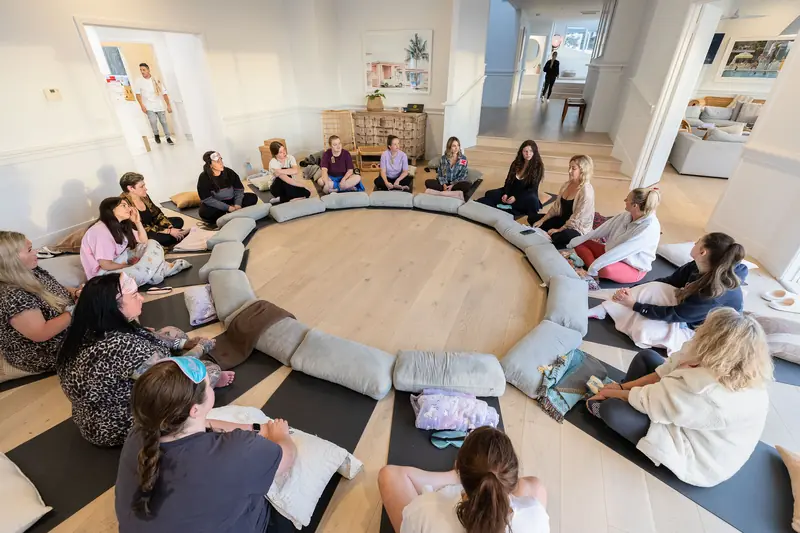 Guests sitting around a ring of bolsters on the studio floor