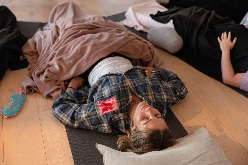 Guests resting under blankets after breathwork, eye masks on