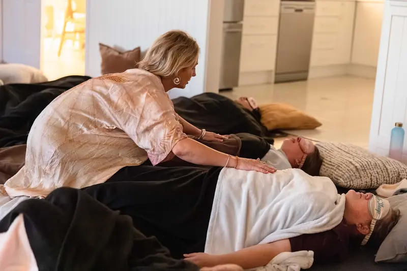 A practitioner settling a guest during a breathwork session