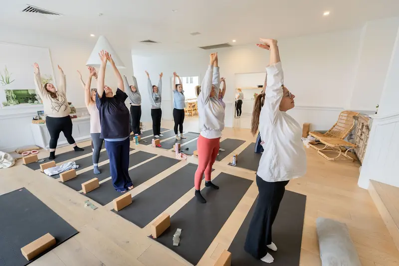 Reaching up together in a morning yoga class
