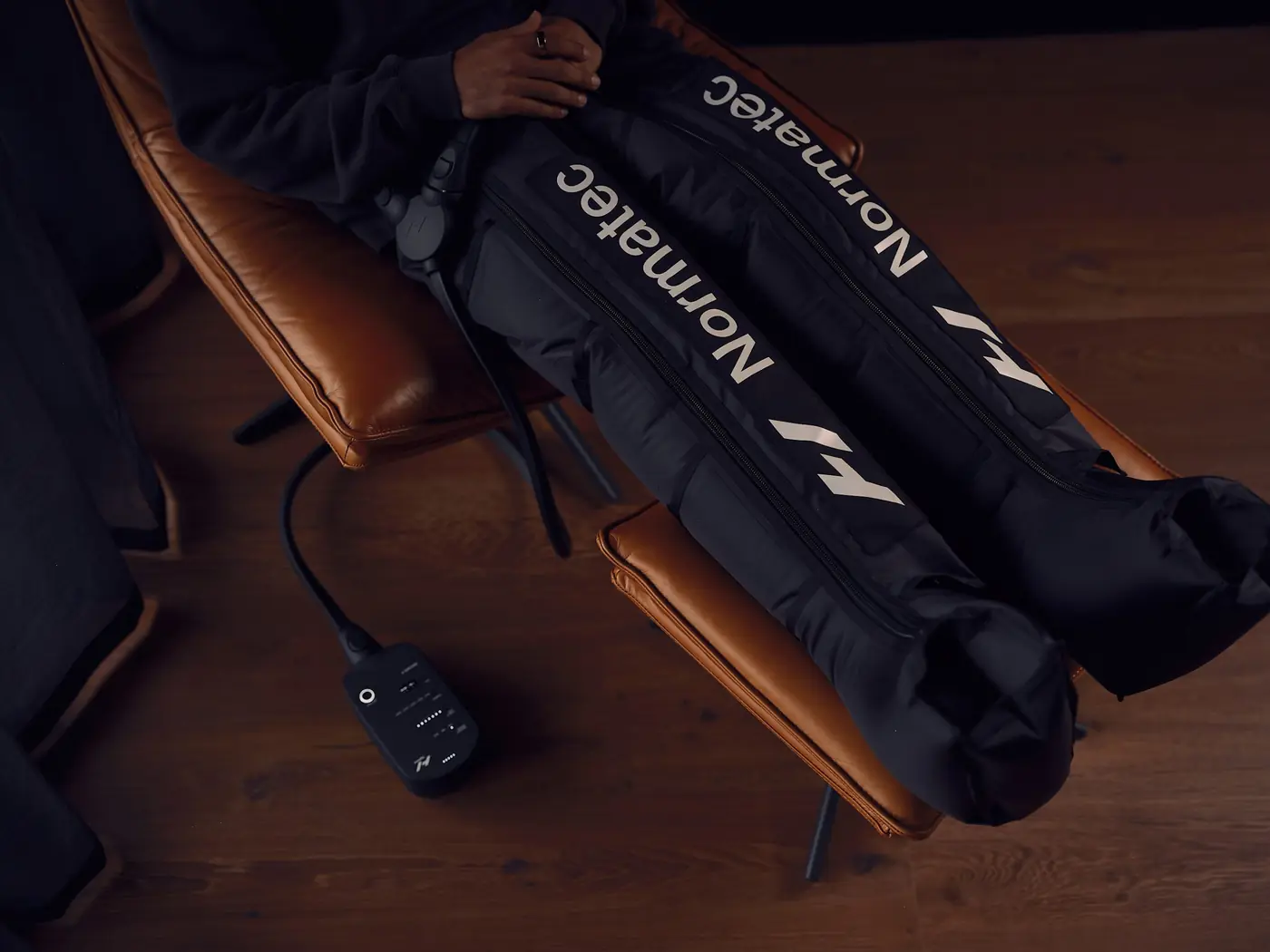 Compression recovery boots laid on a leather lounger