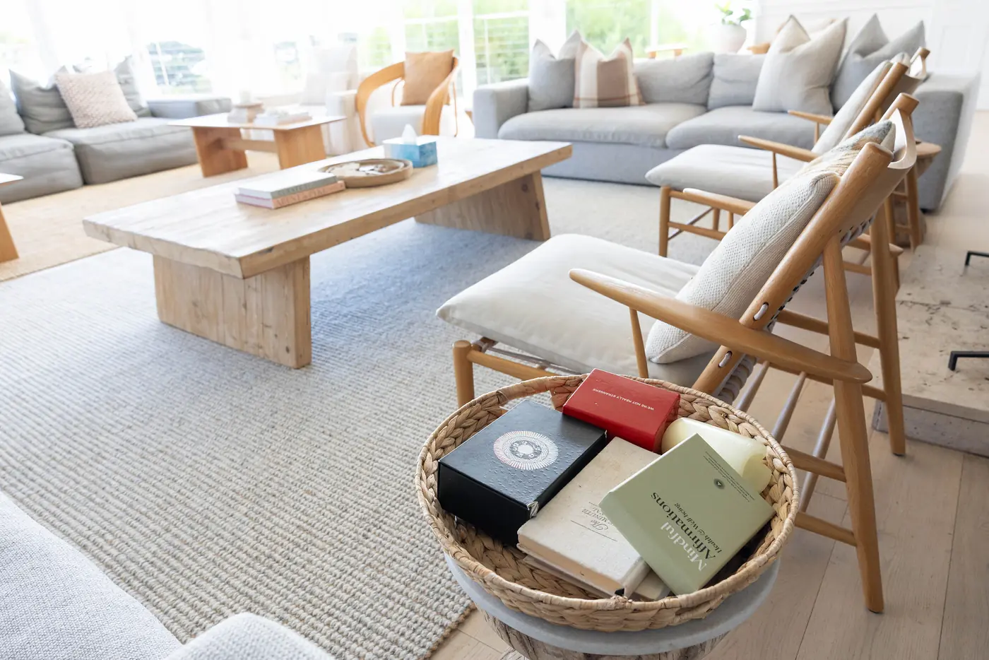 A sitting room with a timber coffee table and a basket of books
