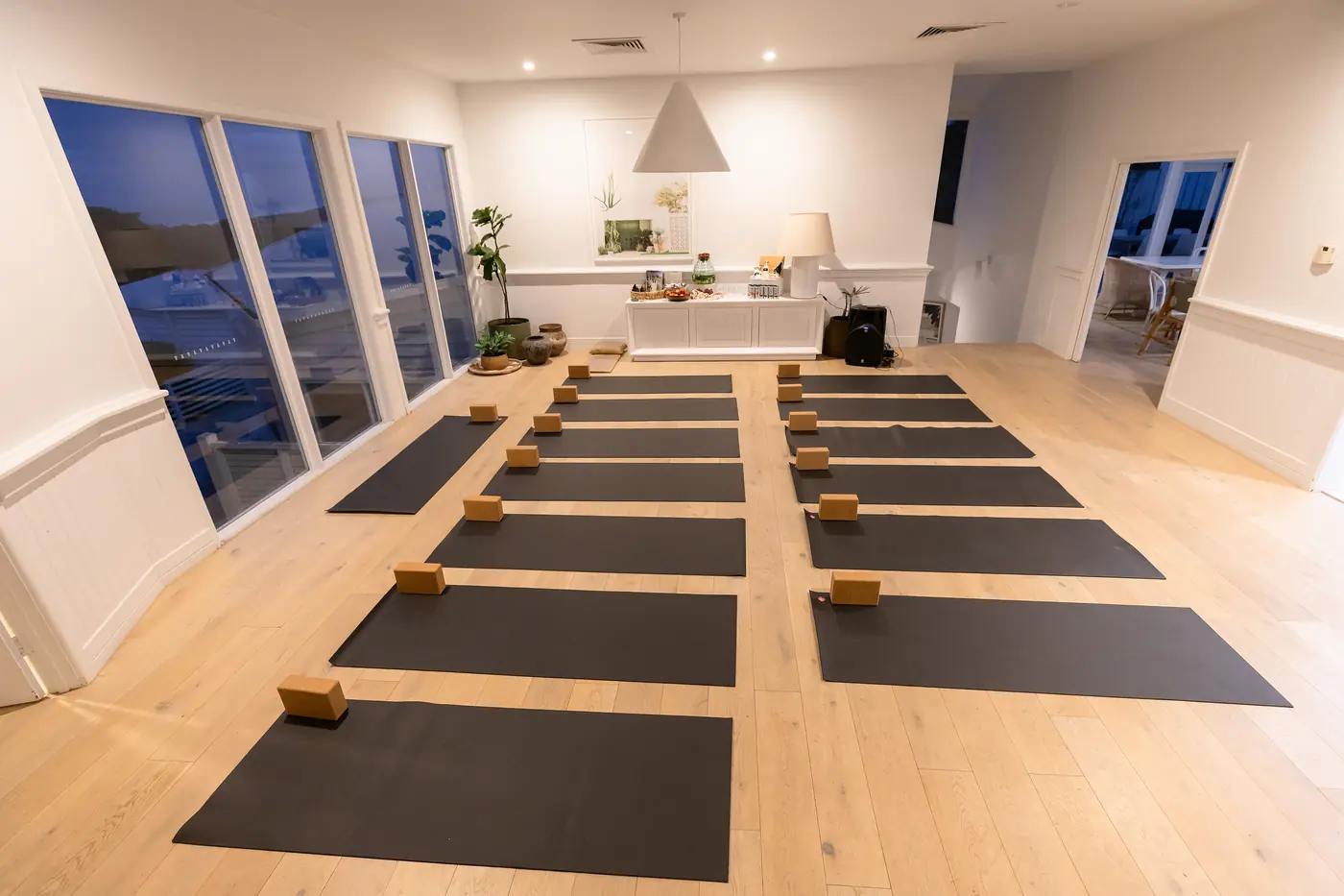 The movement studio at dusk, yoga mats laid out in rows