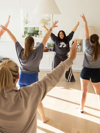Arms up in the sunlit dance class