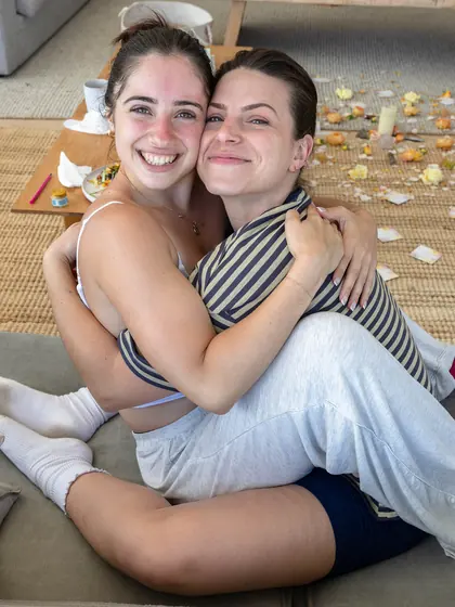 Two guests cuddled up, beaming at the camera