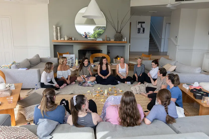 The whole group in a circle on the lounge-room floor