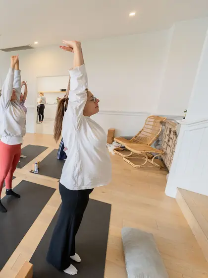 Reaching up together in a morning yoga class